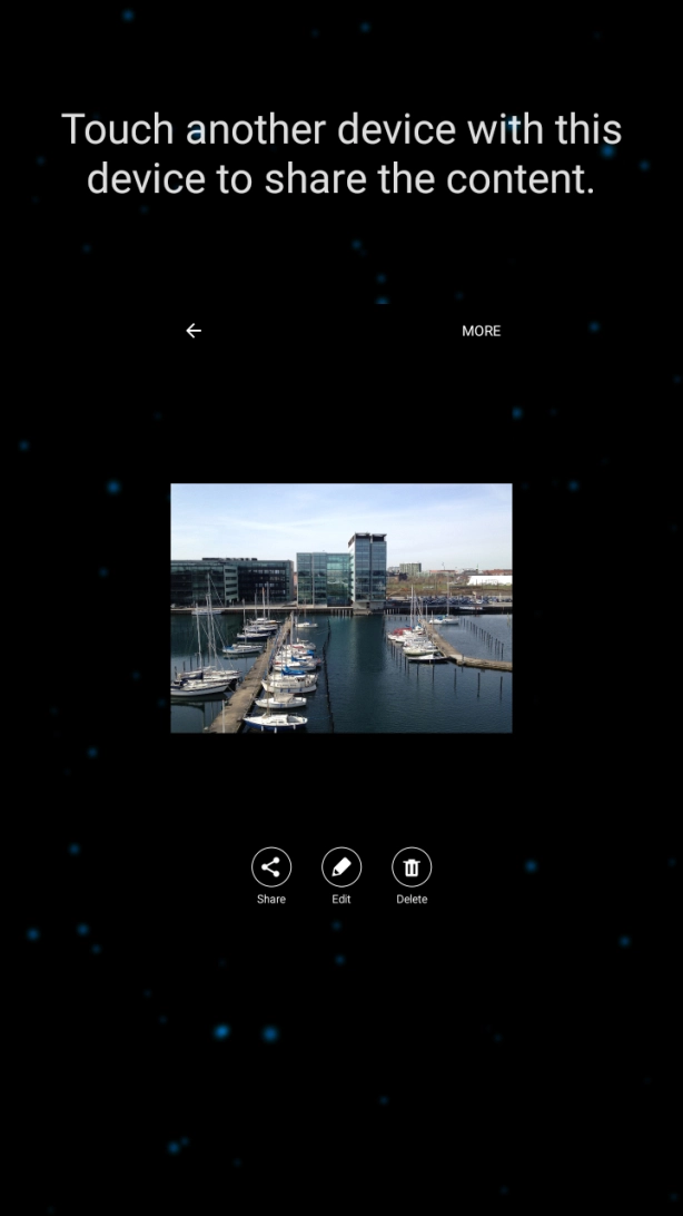 Hold the back of your phone close to back of the receiving device. Press Touch another device with this device to share the content. and wait while the file is transferred.